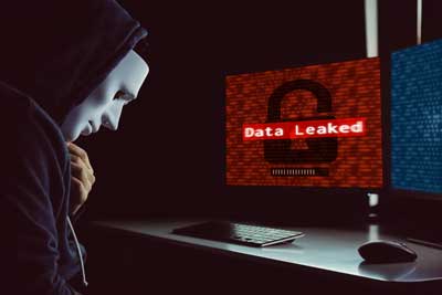 IT professionals responding to a data breach with warning alerts on monitors and security tools in use.